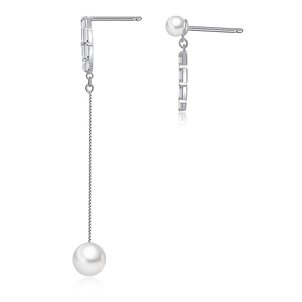 A detailed view of the asymmetrical design of the pearl drop dangler earrings