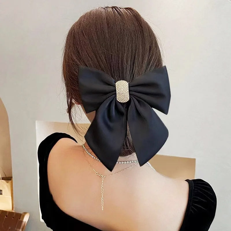 A woman wearing the black bowknot hair clip, showcasing its elegant style.