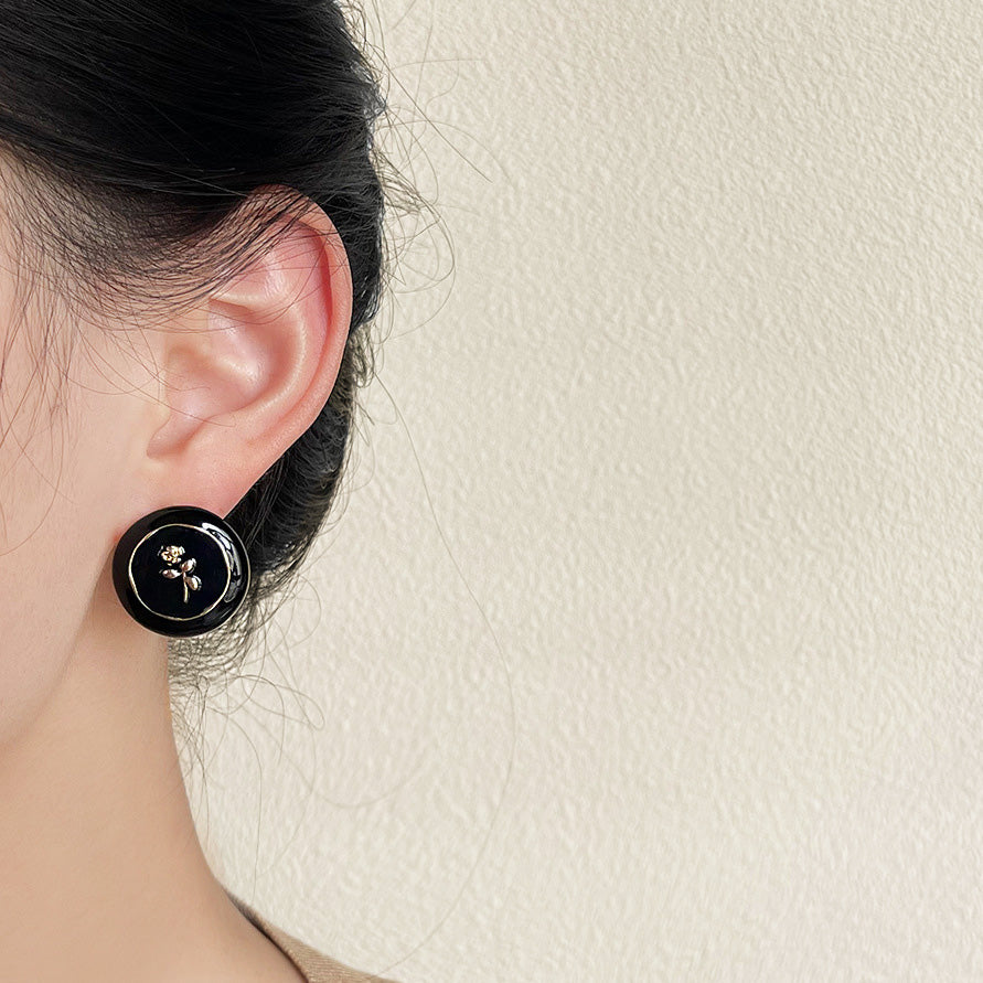 A model showcasing the elegant black and gold stud earring.