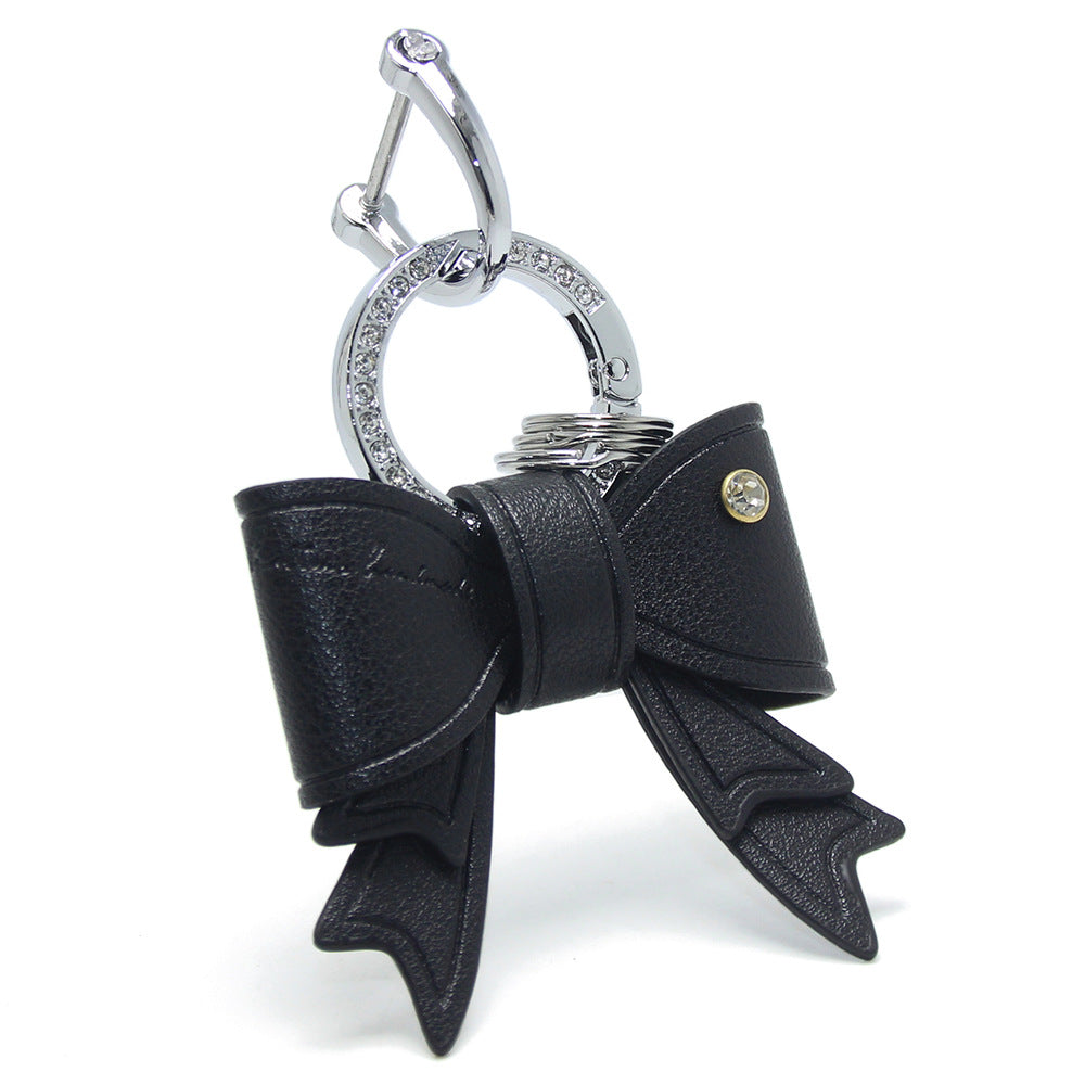Close-up of the black PU leather bow keychain with rhinestone detail