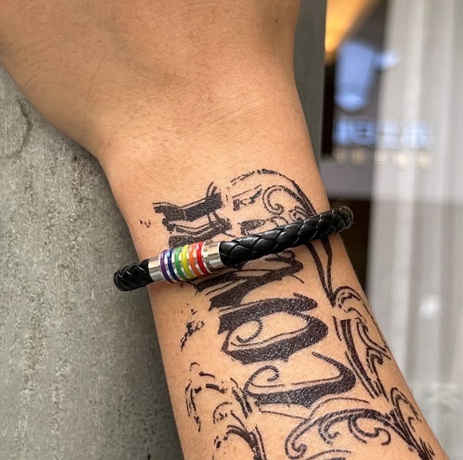 Man wearing the Rainbow PU Leather Bracelet showing the vibrant clasp
