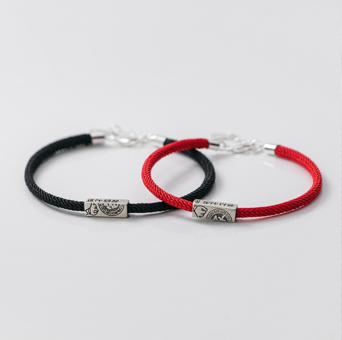 Detailed view of the sterling silver magnetic clasps on the black and red rope bracelets.