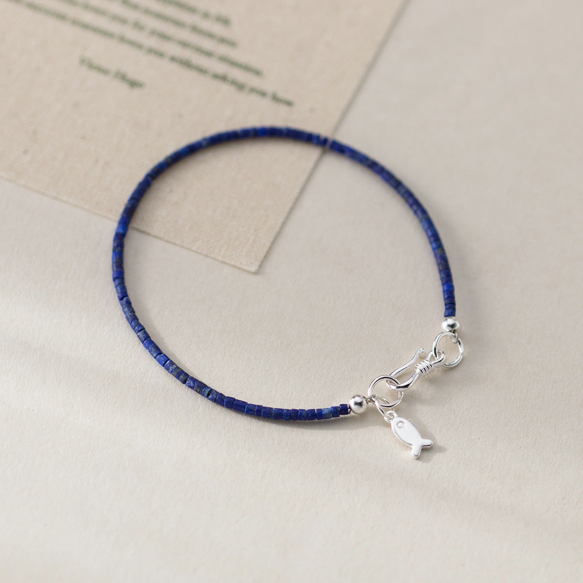 Detailed view of the 925 silver lapis lazuli bracelet with fish charm