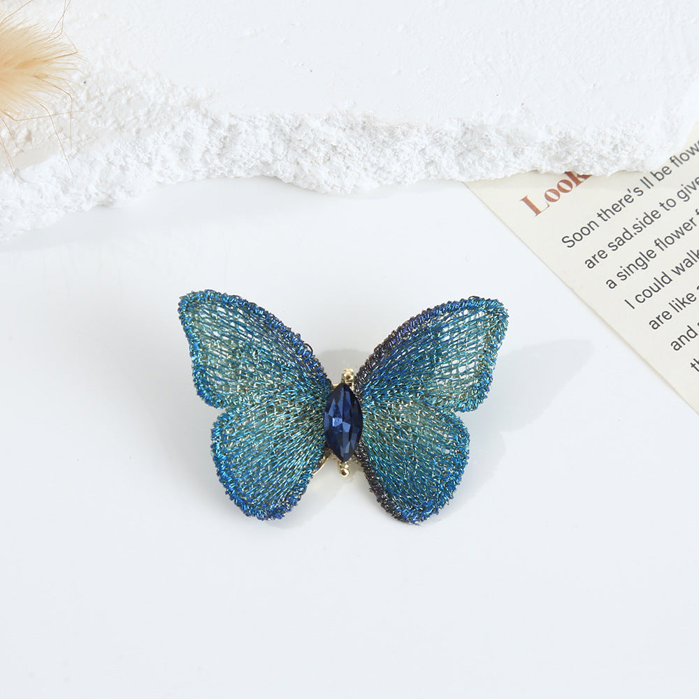 Blue hand-embroidered butterfly brooch shown in detail