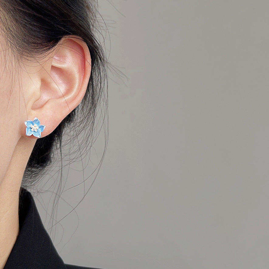 Model showcasing the light blue floral stud earring