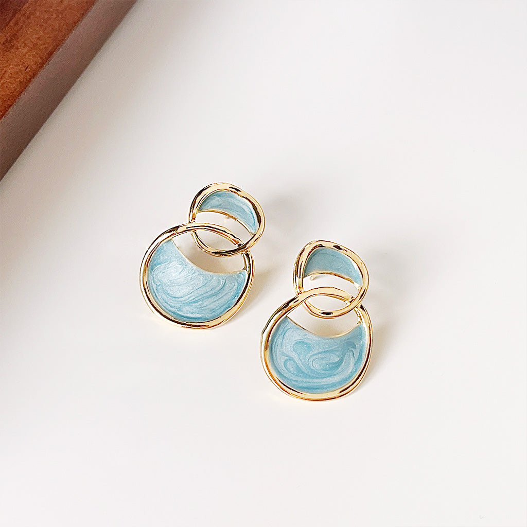 A detailed shot of the blue marbled gold earrings showcasing the intricate enamel work.