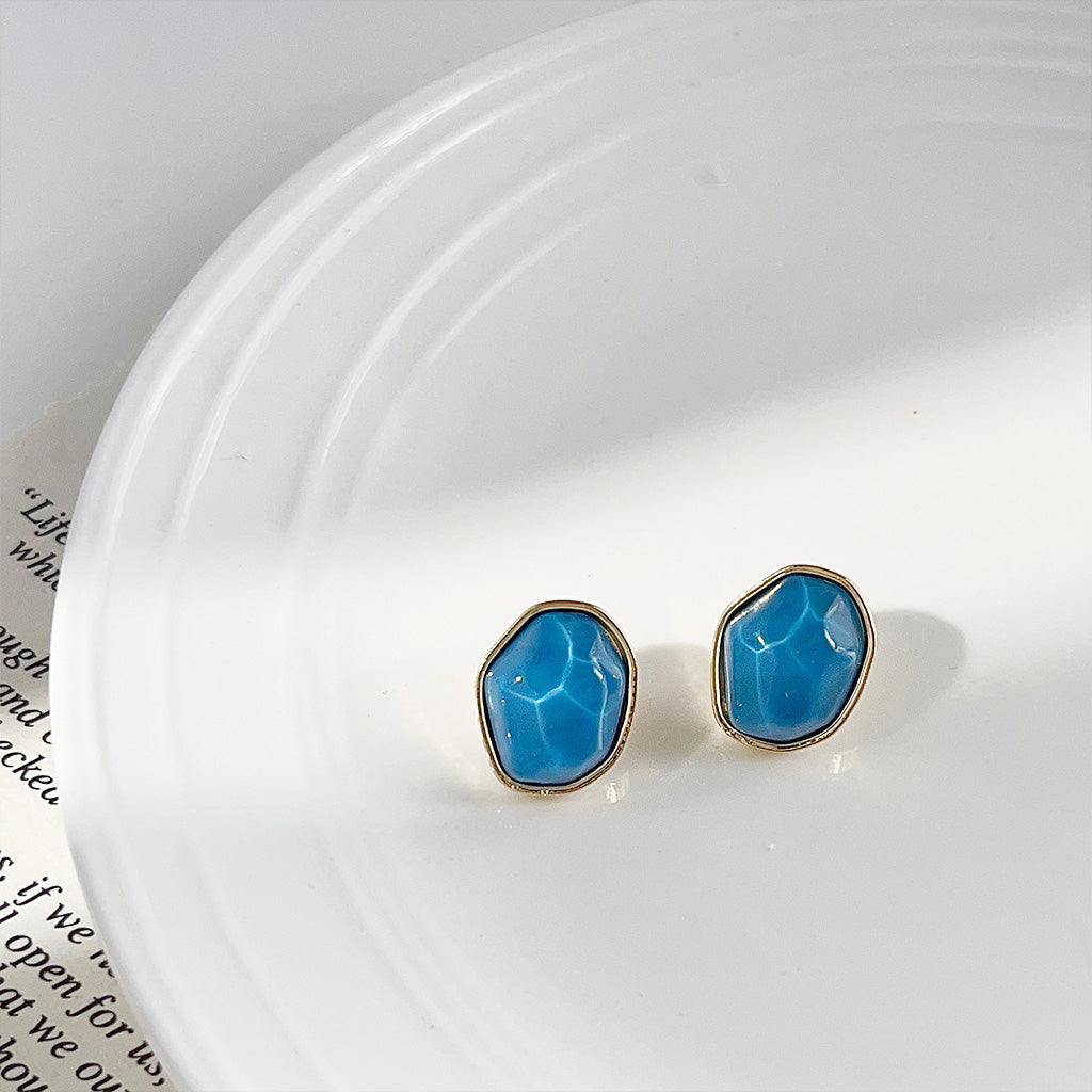 Close-up of the blue resin irregular geometric stud earring with 14K gold plating.