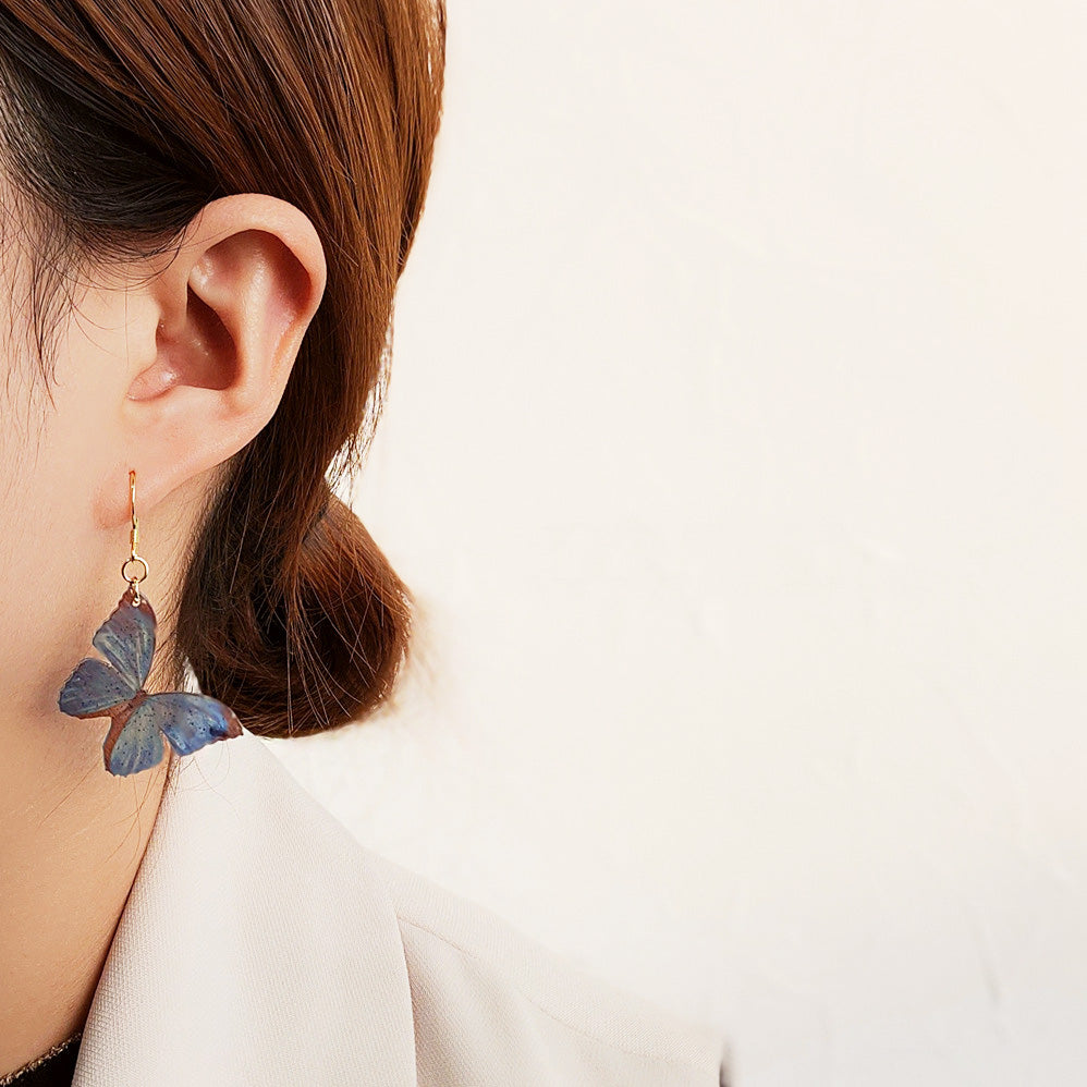 Model showcasing the elegant and lightweight butterfly dangle earring