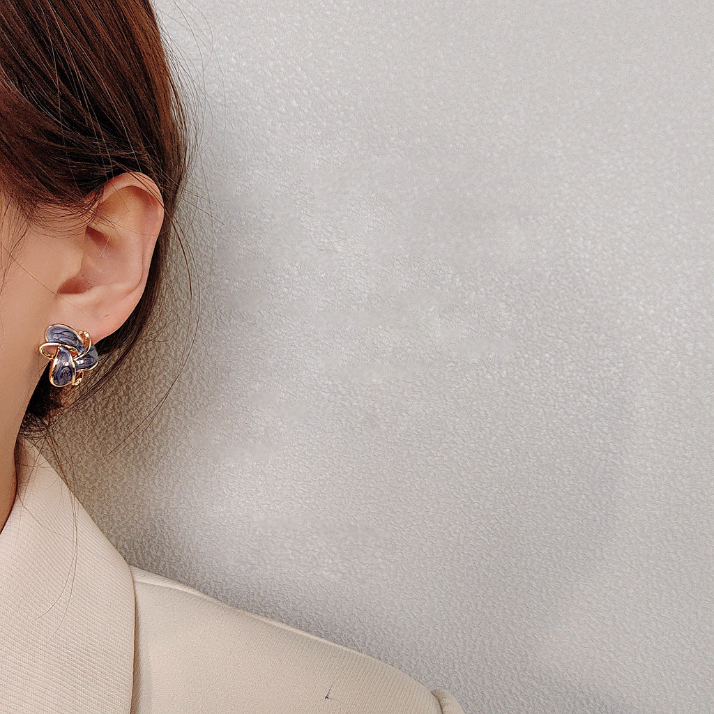 A model wearing a gold-plated butterfly earring with colorful stones, showcasing the style of the geometric earring set.