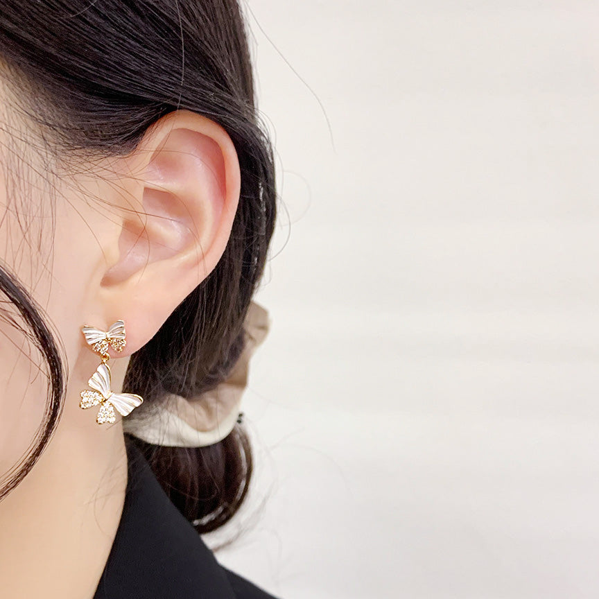 Model wearing the white and gold butterfly statement earrings
