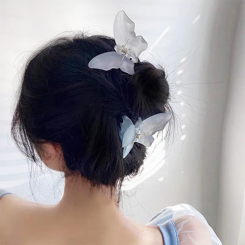 A model wearing multiple butterfly hair clips in different colors