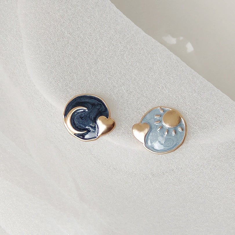 A detailed view of the day and night themed earrings showcasing the intricate enamel work.