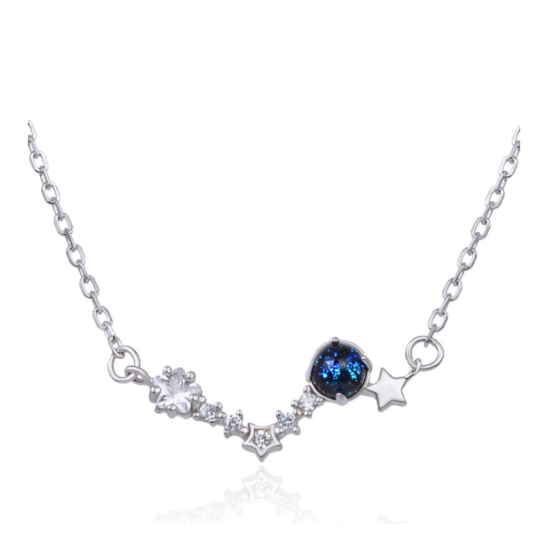 Close-up of the celestial-themed silver necklace pendant with blue gemstone and star charms