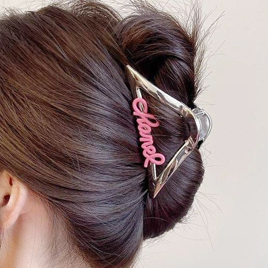 A stylish metal hair clip securing a woman's bun hairstyle.