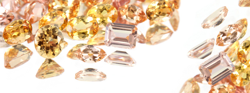A collection of warm-toned topaz and citrine gemstones, the birthstones for November.