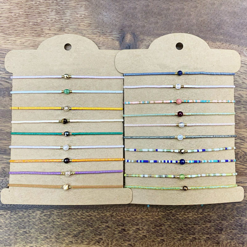 A display of various colorful bohemian beaded bracelets on cards