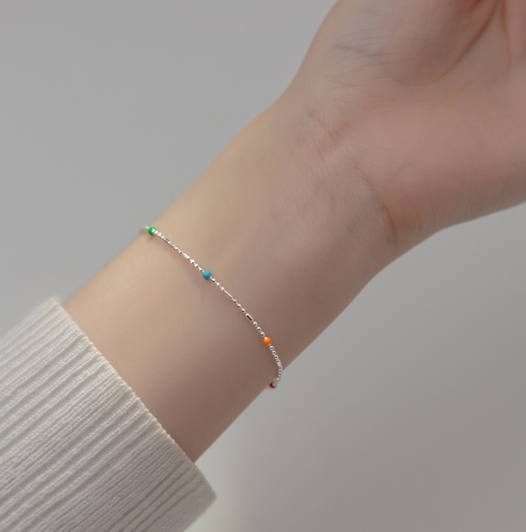 A model showcasing the 925 Sterling Silver Beaded Bracelet on her wrist