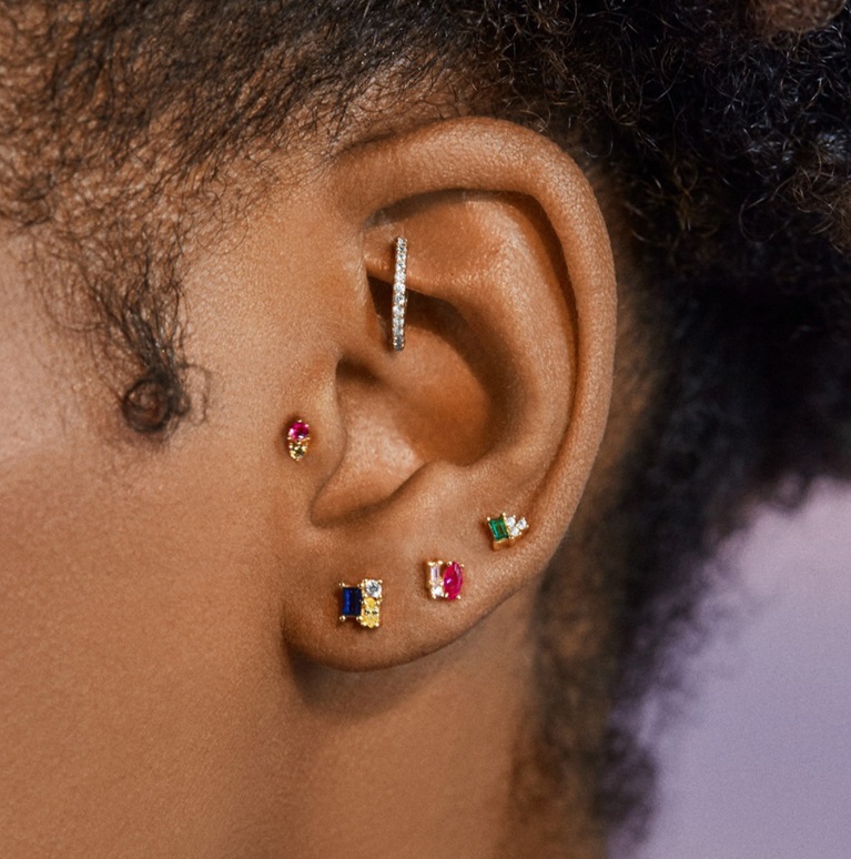 A model wearing a colorful gemstone stud earring, showcasing the fit and style.