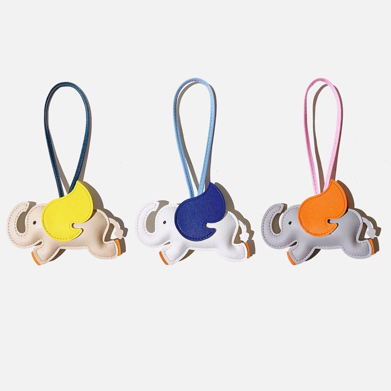 A collection of three colorful PU leather elephant bag charms in white, grey, and ivory.