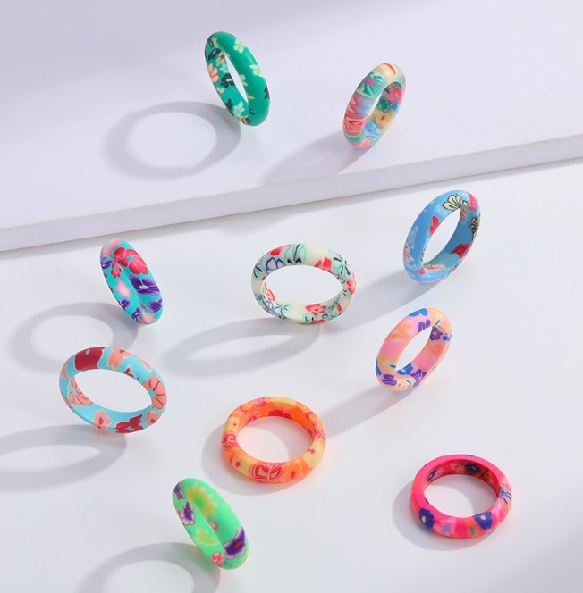 A collection of colorful floral bracelets and rings from the summer collection