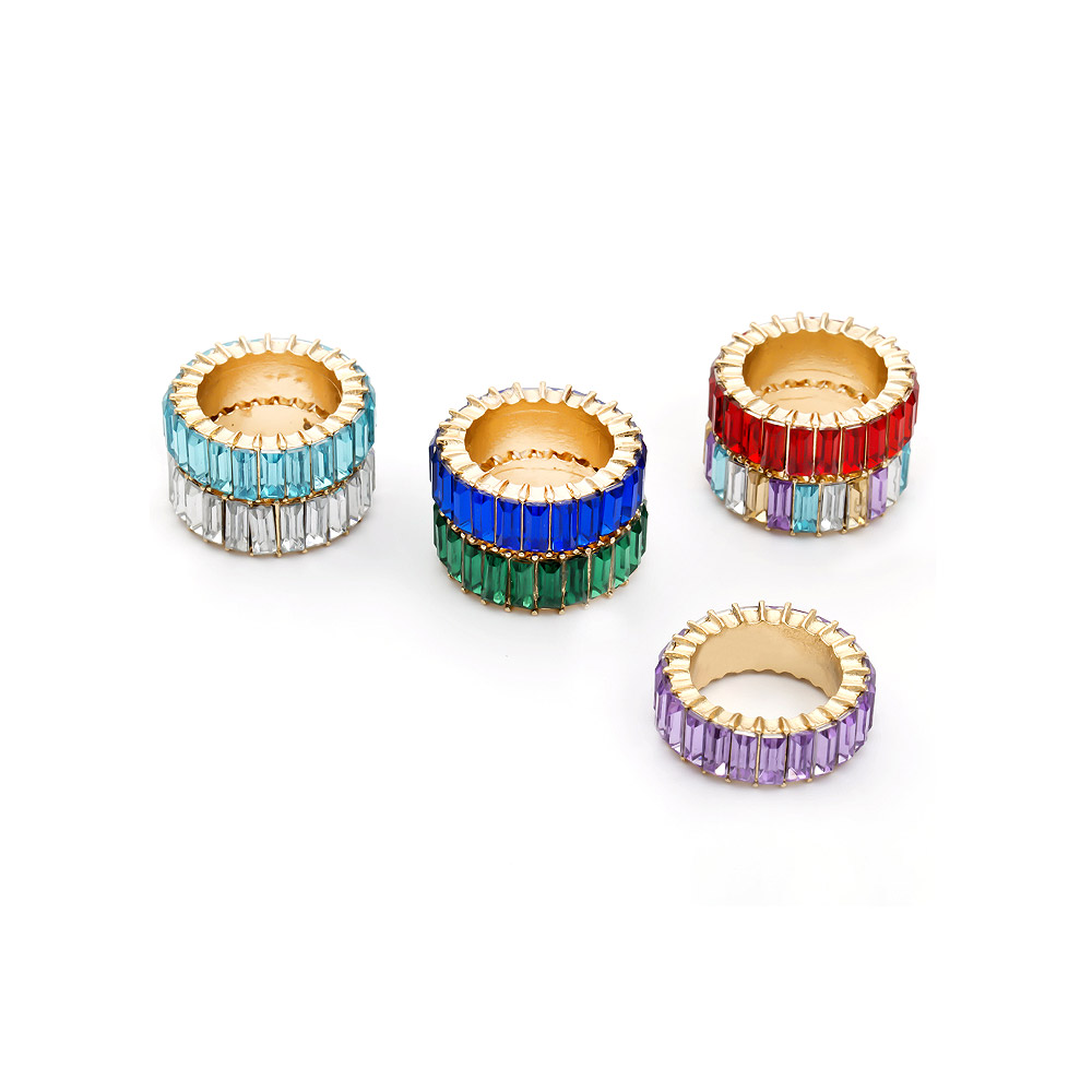 A collection of colorful eternity stack rings in various gemstone colors.
