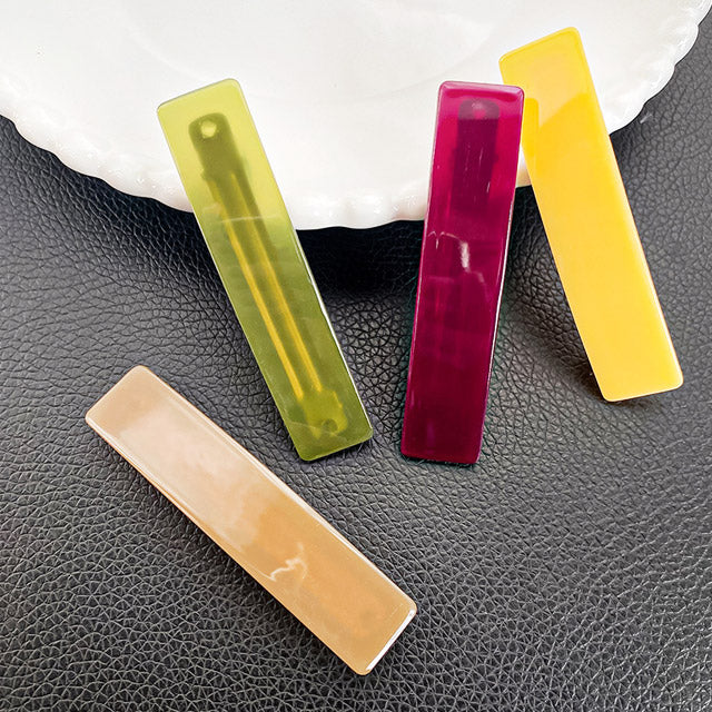 A collection of four colorful rectangle hair clips