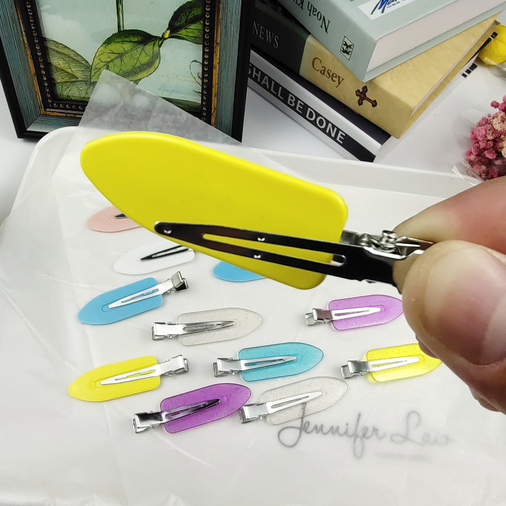 A hand holding a yellow creaseless hair clip, showcasing its design and ease of use.