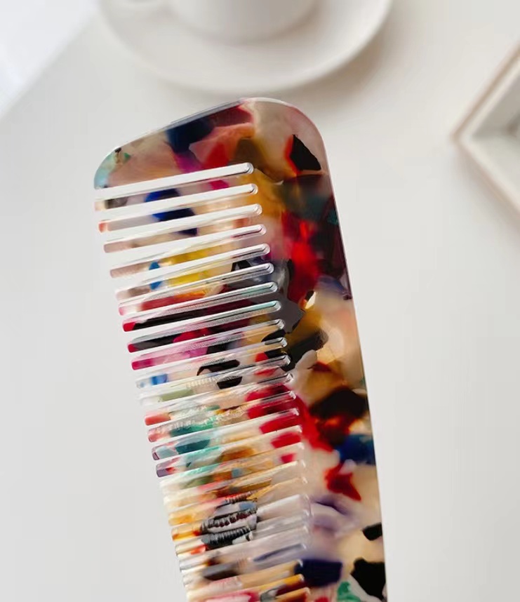 Detailed view of a marbled acetate wide-tooth comb
