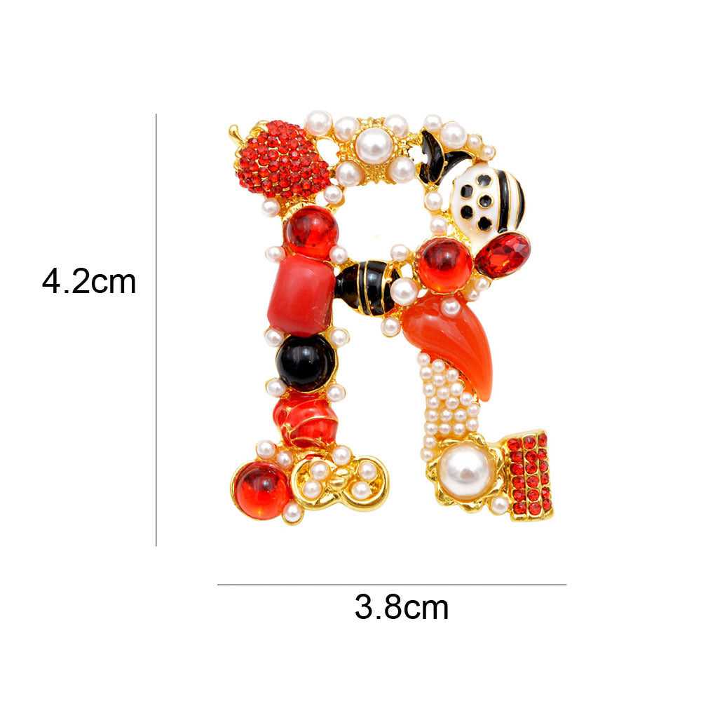 A decorative letter 'D' brooch in baroque style, showcasing the vibrant gemstones and pearl details.