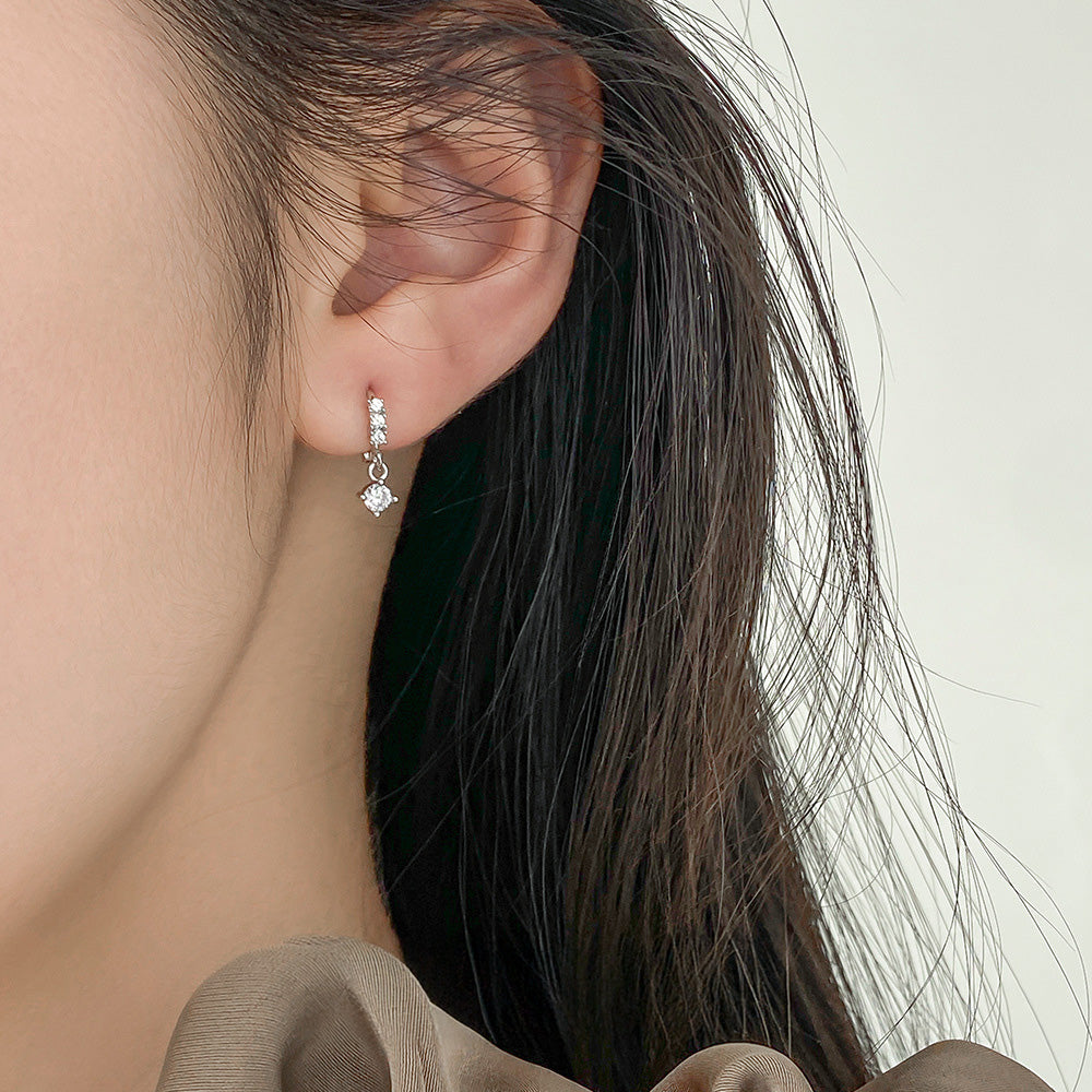 A model wearing the sterling silver geometric square zirconia earring to showcase its elegant look.