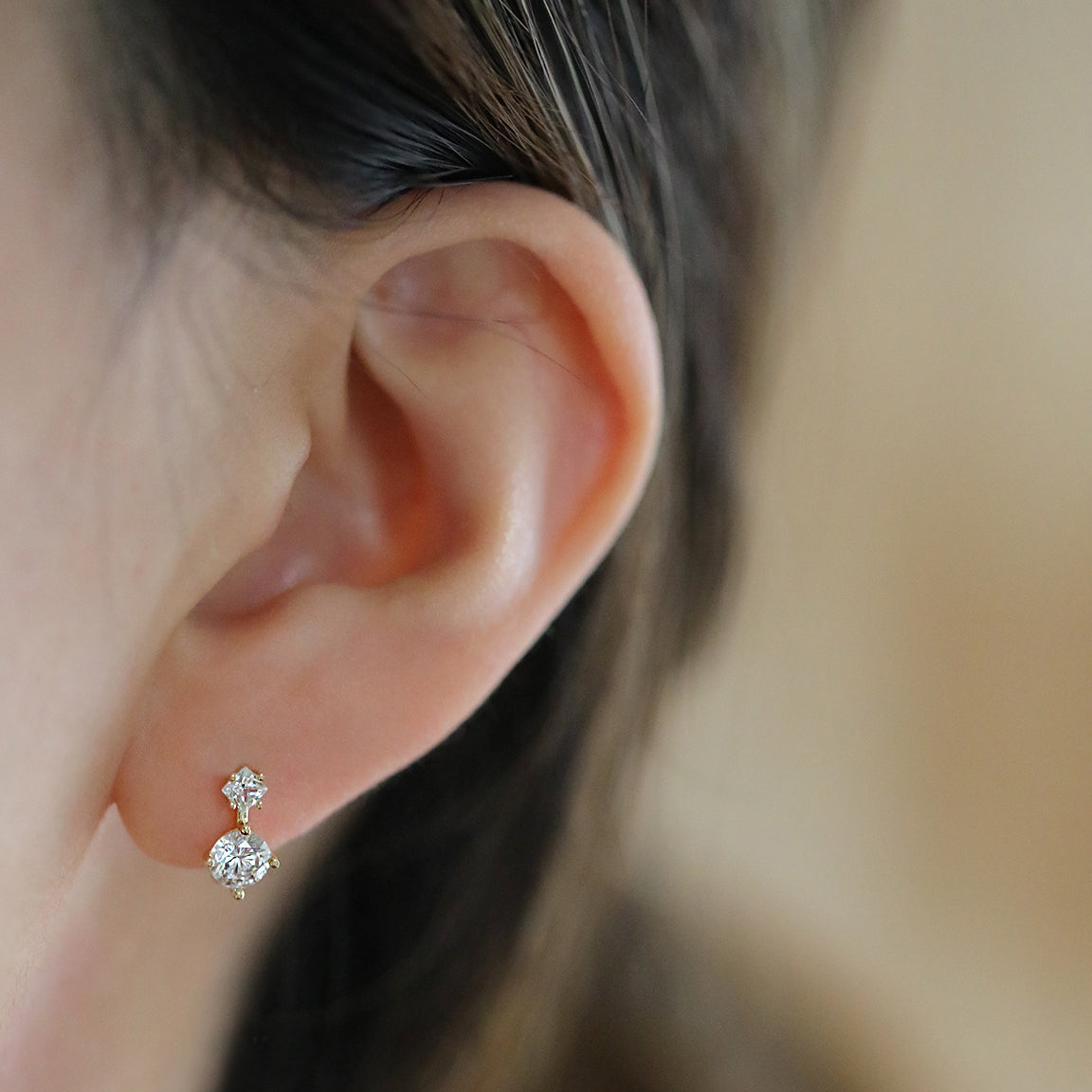 A woman wearing the 925 sterling silver mini crystal huggies hoop earrings.