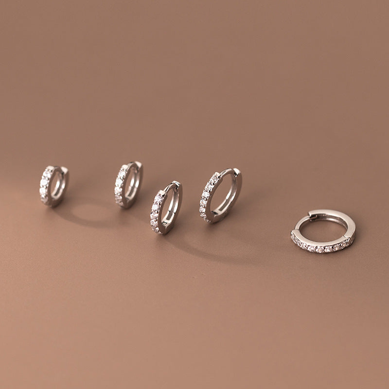 Collection of sterling silver zircon huggie hoops in multiple sizes