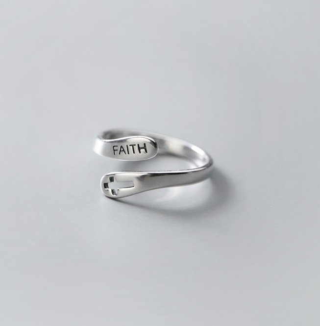 Detailed close-up of the 'FAITH' engraving on the ring