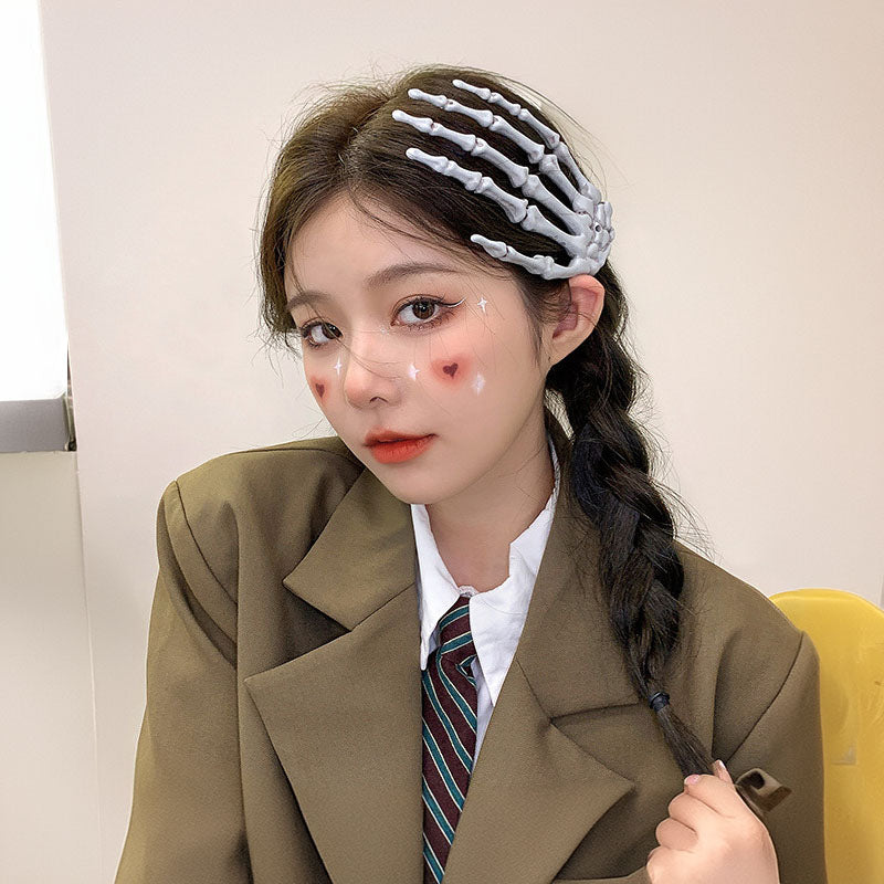 A young woman with a creative hairstyle using the skeleton hand clip as a head accessory.