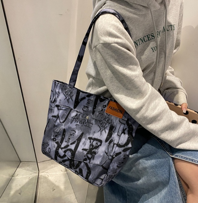 A model carrying the stylish hand-printed PU leather tote bag