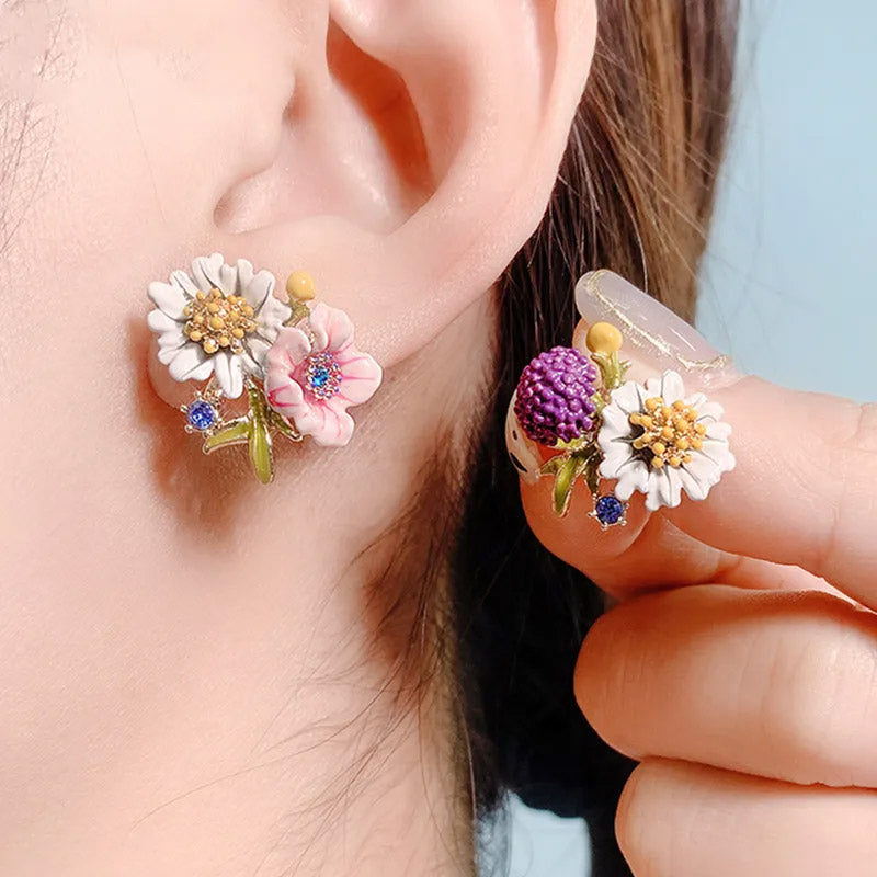 A close-up view of the hand-painted enamel details on the floral earrings.