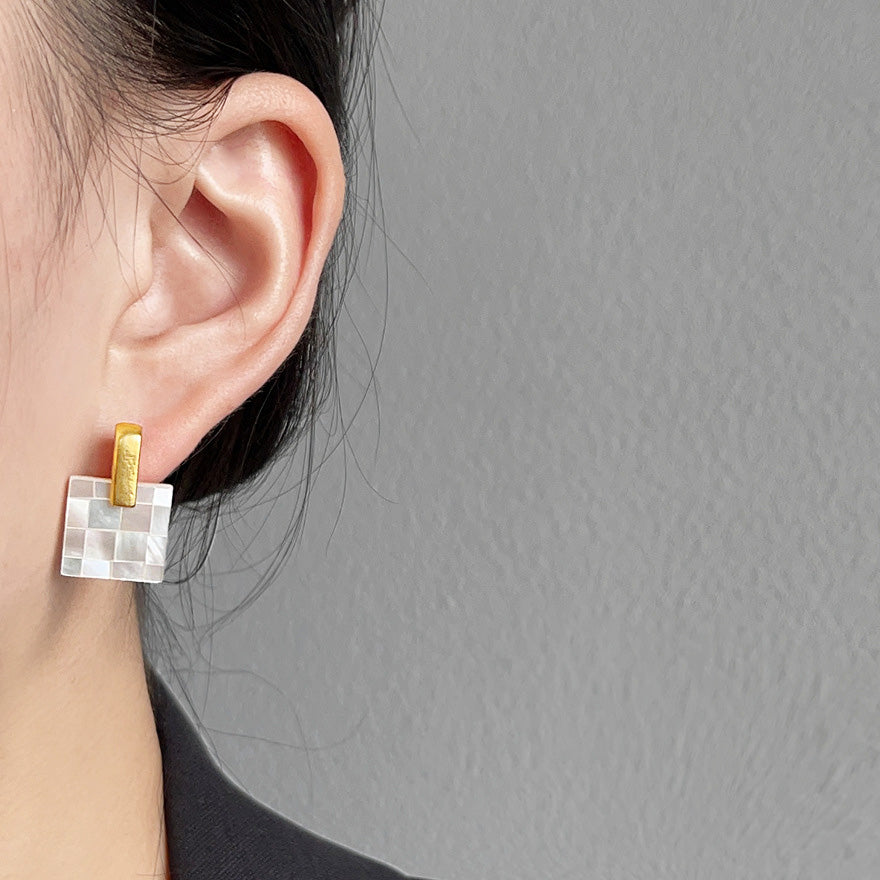 Detailed close-up of a mosaic stud earring showing the mother of pearl shell texture