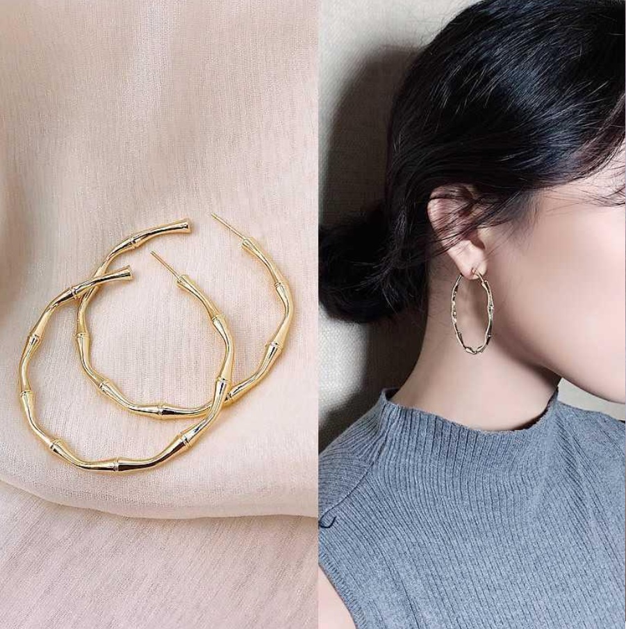 Model showcasing the versatile style of the bamboo textured gold hoop earrings.