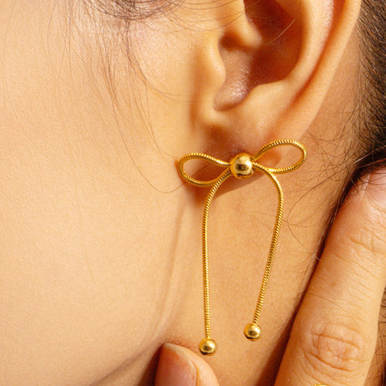 Detailed view of the gold knot bow earring's intricate design.