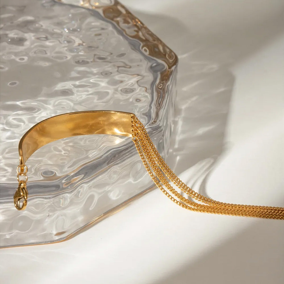 A stylish set of gold stainless steel layered chain bracelets