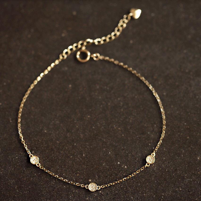 Close-up of the zircon stones on the gold disc bracelet