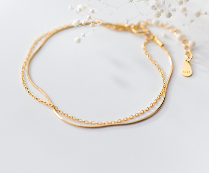 Detailed view of the double-layered chain design of the gold bracelet