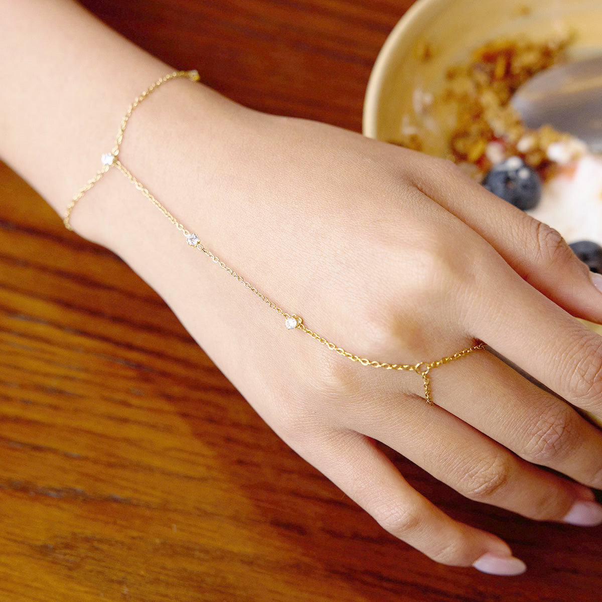 Model wearing the gold plated hand chain bracelet to show its elegant design.