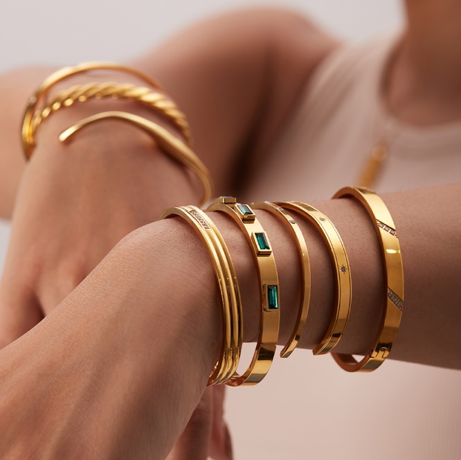 A collection of OEM stainless steel bangles showcasing different plating and gemstone options.