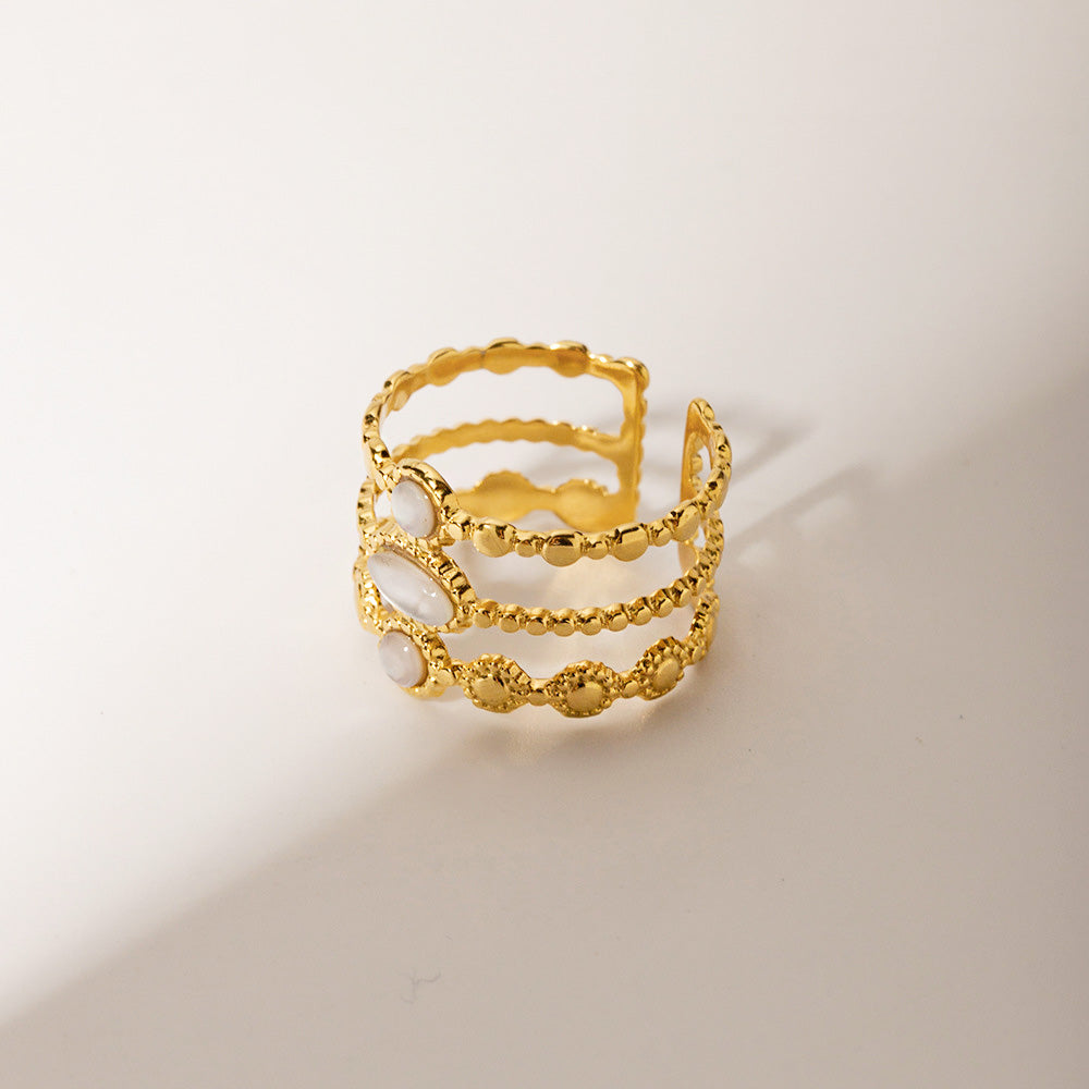 A collection of the gold-plated stainless steel rings with white stone accents displayed together.