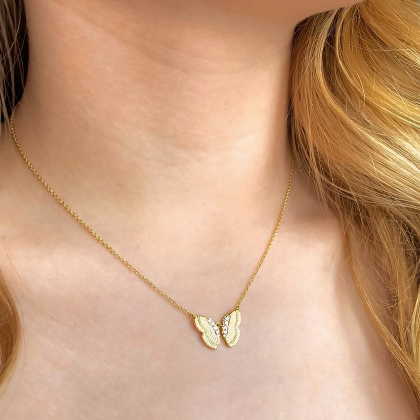 A woman wearing the gold butterfly necklace, showing how it complements her style.