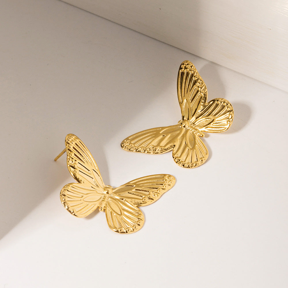 Detailed view of the gold butterfly earrings' textured wings