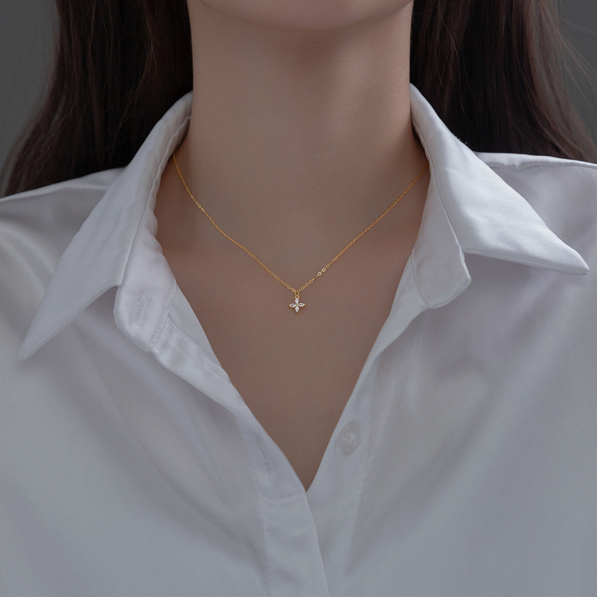 Model showcasing the gold four-leaf clover necklace from JR Fashion Accessories.