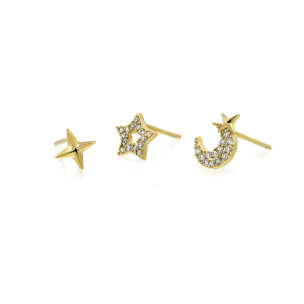A close-up of the three gold celestial earrings: a polished star, a CZ star, and a CZ crescent moon.
