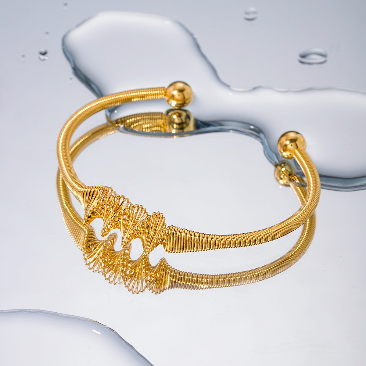 Detailed view of the coiled wire design on a gold cuff bangle